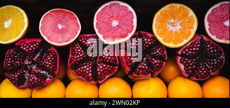 Entnahme von Fruchtscheiben. Reihen von Grapefruit-, Orange- und Granatapfelhälften füllen den Rahmen. Zitrushintergrund: Orangen, Mandarinen, Granatapfel. Ausschneiden Stockfoto