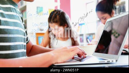 Digitales Bildungskonzept mit Gleichungen und Studenten mit Laptops. Stockfoto