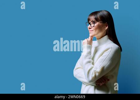 Profilansicht einer glücklichen Frau mittleren Alters, blauer Hintergrund, Kopierraum Stockfoto