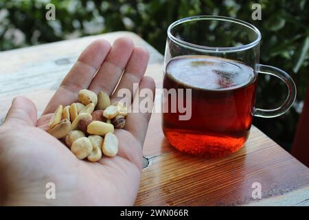 Eine Handvoll Nüsse und eine Tasse schwarzen türkischen Tee. Stockfoto