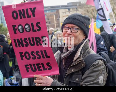 London, Großbritannien. Februar 2024. Nur Narren Versichern Fossile Brennstoffe. Demonstranten der Extinction Rebellion marschierten vom Trinity Square zu einem Festival vor dem Lloyds-Versicherungsgebäude, einige in Geschäftskleidung. Sie fordern, dass sich die Versicherungsbranche weigert, die Entwicklung fossiler Brennstoffe zu decken, da diese unsere Zukunft gefährden. 40 % der weltweiten Produktion fossiler Brennstoffe sind von Lloyds versichert. Peter Marshall/Alamy Live News Stockfoto