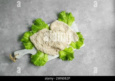 Gereinigte und gewaschene rohe Rinderkutschen auf Schneidebrett auf dunklem rustikalem Tisch Stockfoto