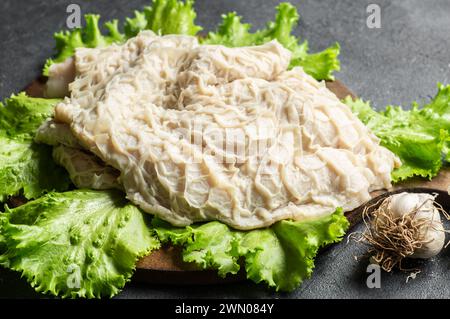 Gereinigte und gewaschene rohe Rinderkutschen auf Schneidebrett auf dunklem rustikalem Tisch Stockfoto