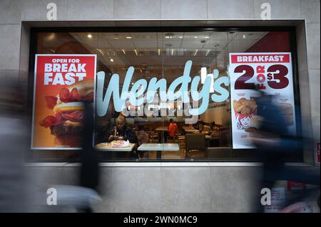 New York, USA. Februar 2024. Wendys Fast-Food-Kette Logo am Fenster des Restaurants in Midtown Manhattan, New York, NY, 28. Februar 2024. Ein Sprecher von Wendy's kündigte an, dass die Restaurantkette während der Stoßzeiten keine „Preissteigerungen“ oder „dynamische Preisgestaltung“ einführen werde, wie bereits früher in der Woche berichtet. (Foto: Anthony Behar/SIPA USA) Credit: SIPA USA/Alamy Live News Stockfoto