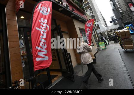 New York, USA. Februar 2024. Wendys Fast Food-Kette Logo auf Flaggen vor einem der Restaurants in Midtown Manhattan, New York, NY, 28. Februar 2024. Ein Sprecher von Wendy's kündigte an, dass die Restaurantkette während der Stoßzeiten keine „Preissteigerungen“ oder „dynamische Preisgestaltung“ einführen werde, wie bereits früher in der Woche berichtet. (Foto: Anthony Behar/SIPA USA) Credit: SIPA USA/Alamy Live News Stockfoto