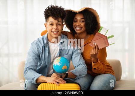 Glückliches afroamerikanisches Paar mit Reisepässen und Bordkarten bereit für die Reise Stockfoto