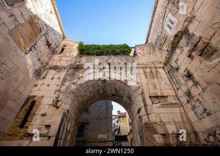 Straßenblick auf die oberen Stockwerke von mittelalterlichen Wohnhäusern aus Stein in der engen Gasse in der Altstadt von Split, Kroatien. Stockfoto