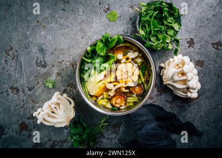 Rindfleisch- und Miso-Knoblauchbrühe, Suppe mit Gemüse, Pilzen und Koriander in einem Topf Stockfoto
