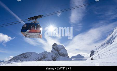 Atemberaubende schneebedeckte Landschaft mit farbenfroher Seilbahn in Mid-Air Stockfoto