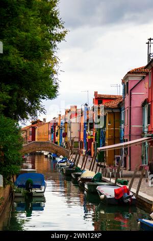 Helle traditionelle farbenfrohe Häuser auf der Insel Burano, Venedig, Italien. Malerische enge alte Straße mit Kanal, Booten und fabelhaften bunten Gebäuden. Stockfoto