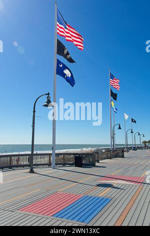 An sonnigen Wintertagen fliegen patriotische Fahnen über die Promenade am Myrtle Beach South Carolina Stockfoto