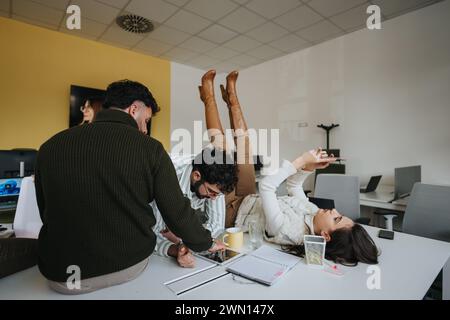 Glückliche, positive Kollegen genießen ihre Pause am Arbeitsplatz. Stockfoto