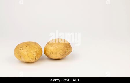 Zwei frische junge Kartoffeln auf weißem Hintergrund. Stockfoto