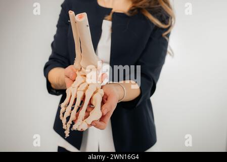 Arzt erklärt Operation zu Fuß auf Knochen-Modell Stockfoto