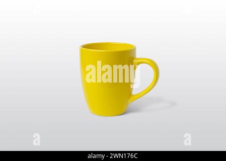 Gelbe Tasse auf grauer Oberfläche für Logo-Branding-Mockup Stockfoto