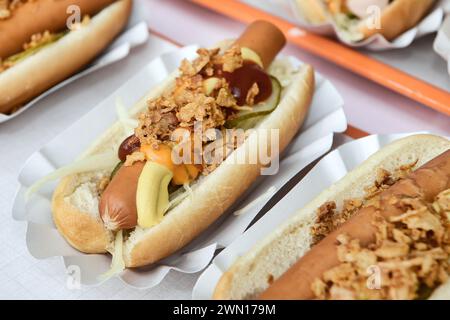 Frankfurter Wurst Hot Dogs serviert mit knusprigen Zwiebelstückchen und Relish, auf Papierteller Stockfoto