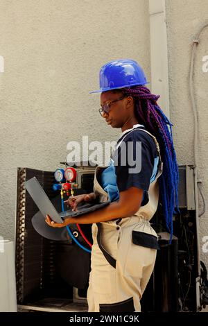 Ein akribischer Experte aus afroamerika sucht online nach neuen Luftfiltern, um bei Wartungsarbeiten im Auftrag des Kunden Fehlfunktionen der Außenklimaanlage zu ersetzen Stockfoto