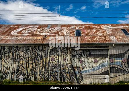 Ein verblasstes Coca Cola-Schild auf einem Blechdach in einem Gebäude in Puerto Natalas, Chile, Südamerika. Stockfoto