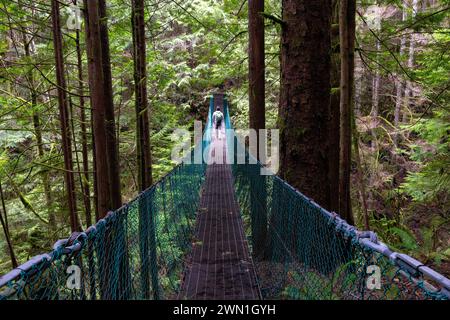 Wanderer auf der Hängebrücke über den Pete Wolfe Creek auf dem Weg nach Mystic Beach - Sooke, Vancouver Island, British Columbia, Kanada Stockfoto