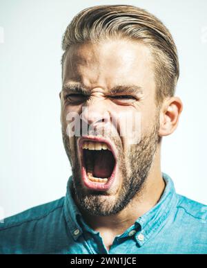 Nahaufnahme Porträt eines wütenden, unzufriedenen Mannes, der schreiend ist. Wütender Mann mit aufgerissenem Mund. Stress und negative Emotionen. Wut und aggressives Konzept Stockfoto