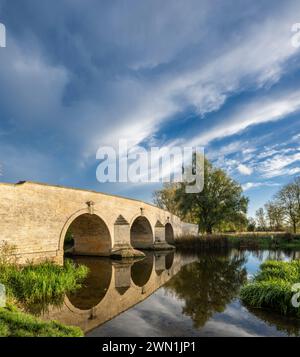 Milton Ferry Bridge, eine alte Kalksteinbrücke über den Fluss Nene, Ferry Meadows, Peterborough, England, mit spektakulärem Himmel Stockfoto