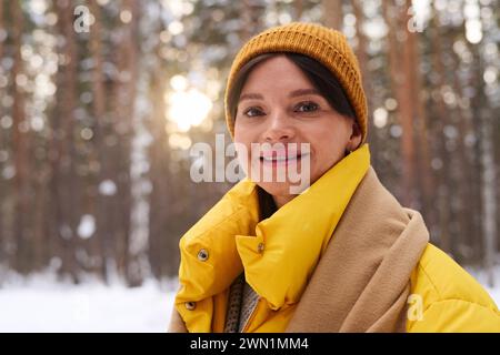 Mittlere Nahaufnahme einer fröhlichen kaukasischen Frau, die warme Kleidung trägt und draußen steht, am Wintertag lächelnd in die Kamera lächelte Stockfoto