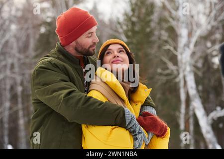 Junge kaukasische Männer und verliebte Frauen wandern an frostigen Wintertagen umarmt und flirtet, Kopierraum Stockfoto