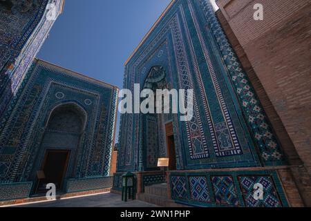 24. JUNI 2023, SAMARKAND, USBEKISTAN: Historischer Friedhof von Shahi Zinda mit seinen fein verzierten Mausoleen durch einen Bogen in Samarkand, Usbekistan Stockfoto