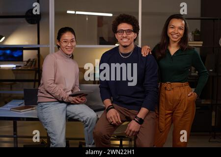 Porträt von drei jungen, ethnisch unterschiedlichen Programmierern, die in modernen Büros vor der Kamera posieren Stockfoto