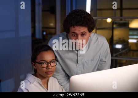 Birassische Männer und Frauen arbeiten nachts am Projekt in modernen IT-Firmenbüros Stockfoto