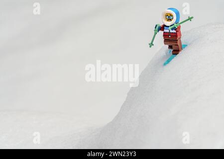 Chappaqua, NY - 13. Februar 2024 - lustiger Gesichtsausdruck auf der verängstigten Lego Minifigur Abfahrtsskifahrer an einem zu steilen Hang. Wintersport Humor. Stockfoto