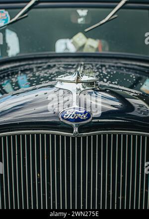 Thames, Neuseeland, 24. November 2022, Beach Hop Car Rally: Detail Shot – restaurierter schwarzer Vintage ford mit Regentropfen und Reflexen auf der Motorhaube. Stockfoto