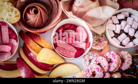 Eine Party-Platte für eine Kindergeburtstagsfeier mit bunten Speisen, süß und herzhaft, darunter Wurst, Obst, Cracker, Kekse, Lollies, Süßigkeiten. Stockfoto