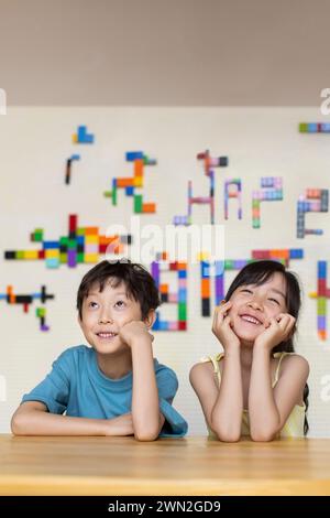 Niedliche Kinder, die im Unterricht denken Stockfoto