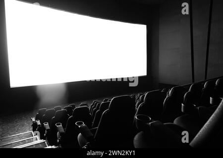 Dunkles Kino mit Leinwand und Stühlen Stockfoto