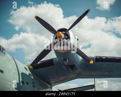 Propeller und Flügel eines alten Flugzeugs vor dem bewölkten Himmel. Nahaufnahme eines tealgrünen Oldtimer-Flugzeugs der 1950er Jahre. Vintage-Luftfahrt. Stockfoto