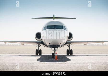 Weißer Passagier-Regionaljet gegenüber der Kamera. Symmetrische frontale Nahaufnahme des Passagier-T-Tail-Flugzeugs auf dem Boden an einem sonnigen Tag. Stockfoto