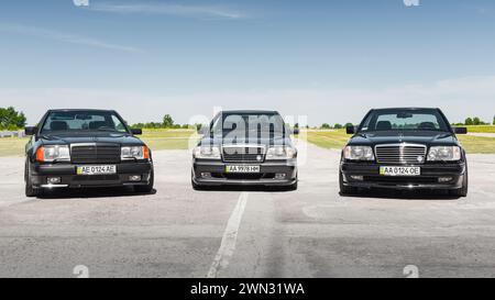 Drei Mercedes-Benz Coupés der E-Klasse C124 (W124). Mercedes-Autos der 1980er-1990er an einem sonnigen Tag auf dem Flugplatz. Stockfoto