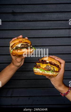 Zwei Freunde essen Cheeseburger vor einer Garage Stockfoto