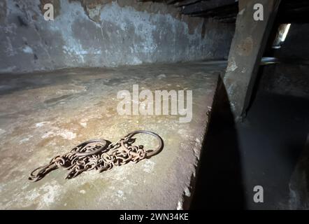 Manakeln in einem unterirdischen Aufbewahrungslager für 50 Sklaven auf dem alten Sklavenmarkt in Stone Town, Sansibar, Tansania. Stockfoto