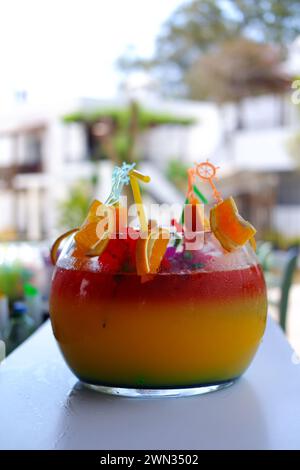 Großes kugelförmiges Glas für Kokzidiosen im Freien auf dem Bartisch im Sommer. Bokeh mit Stühlen im Hintergrund. Stockfoto