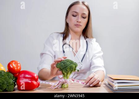 Professionelle Ernährungsberaterin mit Blick auf Obst und Gemüse bei der Konsultation des Patienten. Stockfoto