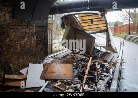 Slough, Berkshire, Großbritannien. Februar 2024. Ein Van ist in der Station Road in Slough nahe der Burnham Station auf die Eisenbahnbrücke gestoßen. Die Niederbrücke, die deutlich als Niederbrücke gekennzeichnet ist und ein blinkendes Schild zur Warnung von Fahrzeugen hat, liegt unterhalb der Eisenbahnlinie, die von Elizabeth Line und GWR-Zügen genutzt wird. Die Züge fahren jedoch noch. Das Fahrerhaus wurde weggefahren und der Inhalt, der wie Baumüll aussieht, wurde verstreut in der Brücke zurückgelassen. Der Van hat ein Logo für Lambournes, 24-Stunden-Hecklift und Shutter-Reparaturen auf der Rückseite. Die Straße ist Stockfoto