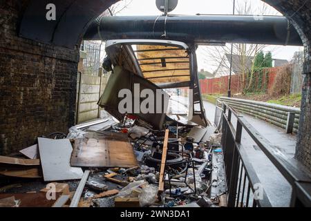 Slough, Berkshire, Großbritannien. Februar 2024. Ein Van ist in der Station Road in Slough nahe der Burnham Station auf die Eisenbahnbrücke gestoßen. Die Niederbrücke, die deutlich als Niederbrücke gekennzeichnet ist und ein blinkendes Schild zur Warnung von Fahrzeugen hat, liegt unterhalb der Eisenbahnlinie, die von Elizabeth Line und GWR-Zügen genutzt wird. Die Züge fahren jedoch noch. Das Fahrerhaus wurde weggefahren und der Inhalt, der wie Baumüll aussieht, wurde verstreut in der Brücke zurückgelassen. Der Van hat ein Logo für Lambournes, 24-Stunden-Hecklift und Shutter-Reparaturen auf der Rückseite. Die Straße ist Stockfoto