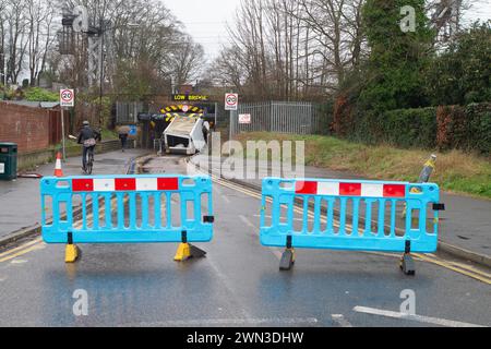 Slough, Berkshire, Großbritannien. Februar 2024. Ein Van ist in der Station Road in Slough nahe der Burnham Station auf die Eisenbahnbrücke gestoßen. Die Niederbrücke, die deutlich als Niederbrücke gekennzeichnet ist und ein blinkendes Schild zur Warnung von Fahrzeugen hat, liegt unterhalb der Eisenbahnlinie, die von Elizabeth Line und GWR-Zügen genutzt wird. Die Züge fahren jedoch noch. Das Fahrerhaus wurde weggefahren und der Inhalt, der wie Baumüll aussieht, wurde verstreut in der Brücke zurückgelassen. Der Van hat ein Logo für Lambournes, 24-Stunden-Hecklift und Shutter-Reparaturen auf der Rückseite. Die Straße ist Stockfoto