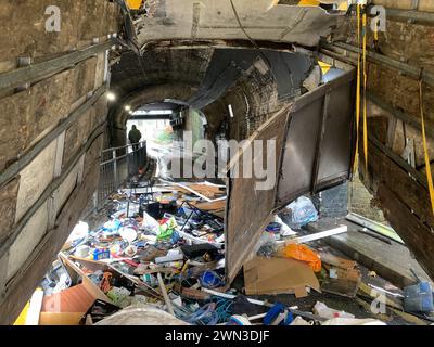 Slough, Berkshire, Großbritannien. Februar 2024. Ein Van ist in der Station Road in Slough nahe der Burnham Station auf die Eisenbahnbrücke gestoßen. Die Niederbrücke, die deutlich als Niederbrücke gekennzeichnet ist und ein blinkendes Schild zur Warnung von Fahrzeugen hat, liegt unterhalb der Eisenbahnlinie, die von Elizabeth Line und GWR-Zügen genutzt wird. Die Züge fahren jedoch noch. Das Fahrerhaus wurde weggefahren und der Inhalt, der wie Baumüll aussieht, wurde verstreut in der Brücke zurückgelassen. Der Van hat ein Logo für Lambournes, 24-Stunden-Hecklift und Shutter-Reparaturen auf der Rückseite. Die Straße ist Stockfoto