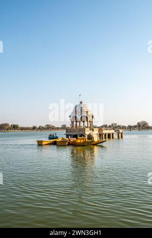 Jaisalmer, Indien - 12. Februar 2024: Die Menschen besuchen mit dem Boot den Gadsisar Sagar See mit historischen Gebäuden, um Regenwasser zu speichern und ein gleichmäßiges Wasser zu gewährleisten Stockfoto