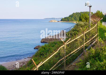 Yangyang County, Südkorea - 30. Juli 2019: Mit Blick auf die felsige Küste der Ostsee, ein Zaun mit Stacheldraht und einem Lautsprecher auf einem Stockfoto