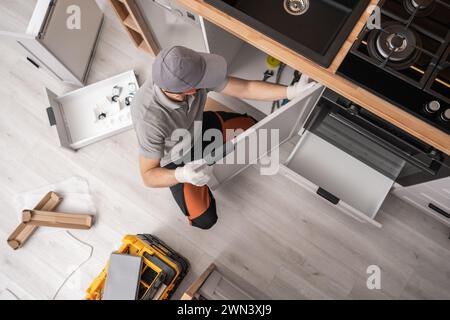 Professioneller Küchenschreiner, der Möbel in einem Apartment installiert Stockfoto