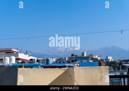 Februar 14T2024, Uttarakhand Indien. Schneebedeckte Gipfel von Mussoorie und Dhanaulti von Dächern von Dehradun, Indien Stockfoto